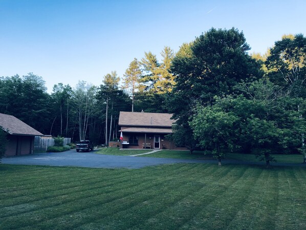 A residential house with a front yard, a driveway, and a flag.
