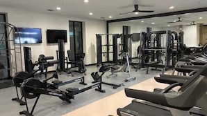 Ein Fitnessstudio mit Laufbändern, Krafttrainingsgeräten und Kurzhanteln.