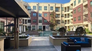 A courtyard with outdoor seating, a pool, and a multi-story building with balconies. - Jade At Millennium - 3 Bed Apt in Houston (Houston)