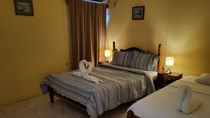 Une chambre d’hôtel avec un lit, une table de chevet avec une lampe et un climatiseur fixé au mur.