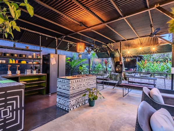 Een koelkast, een kookplaat, kookgerei, borden en bestek