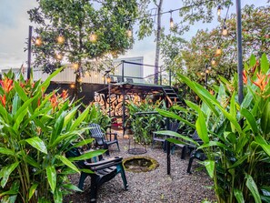 An outdoor seating area with chairs, a small table, and decorative lights.