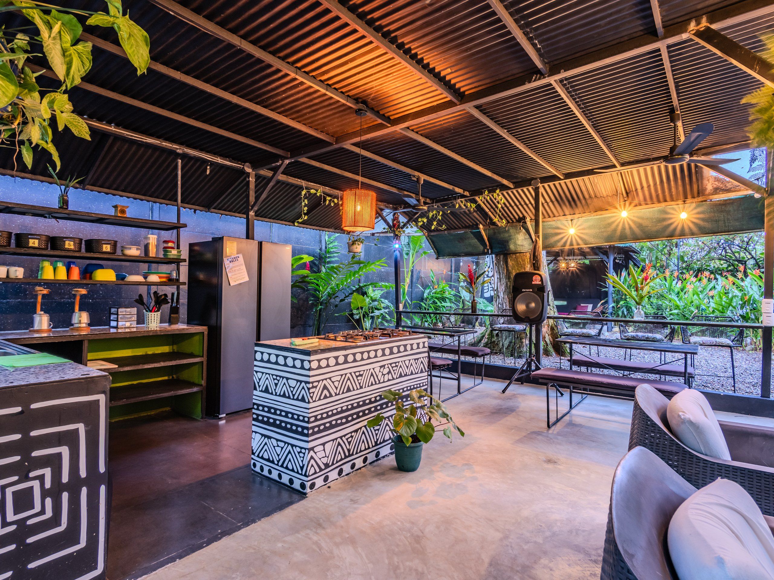 An outdoor bar area with a counter, seating, and potted plants.