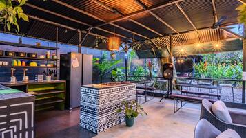 An outdoor bar area with a counter, seating, and potted plants.