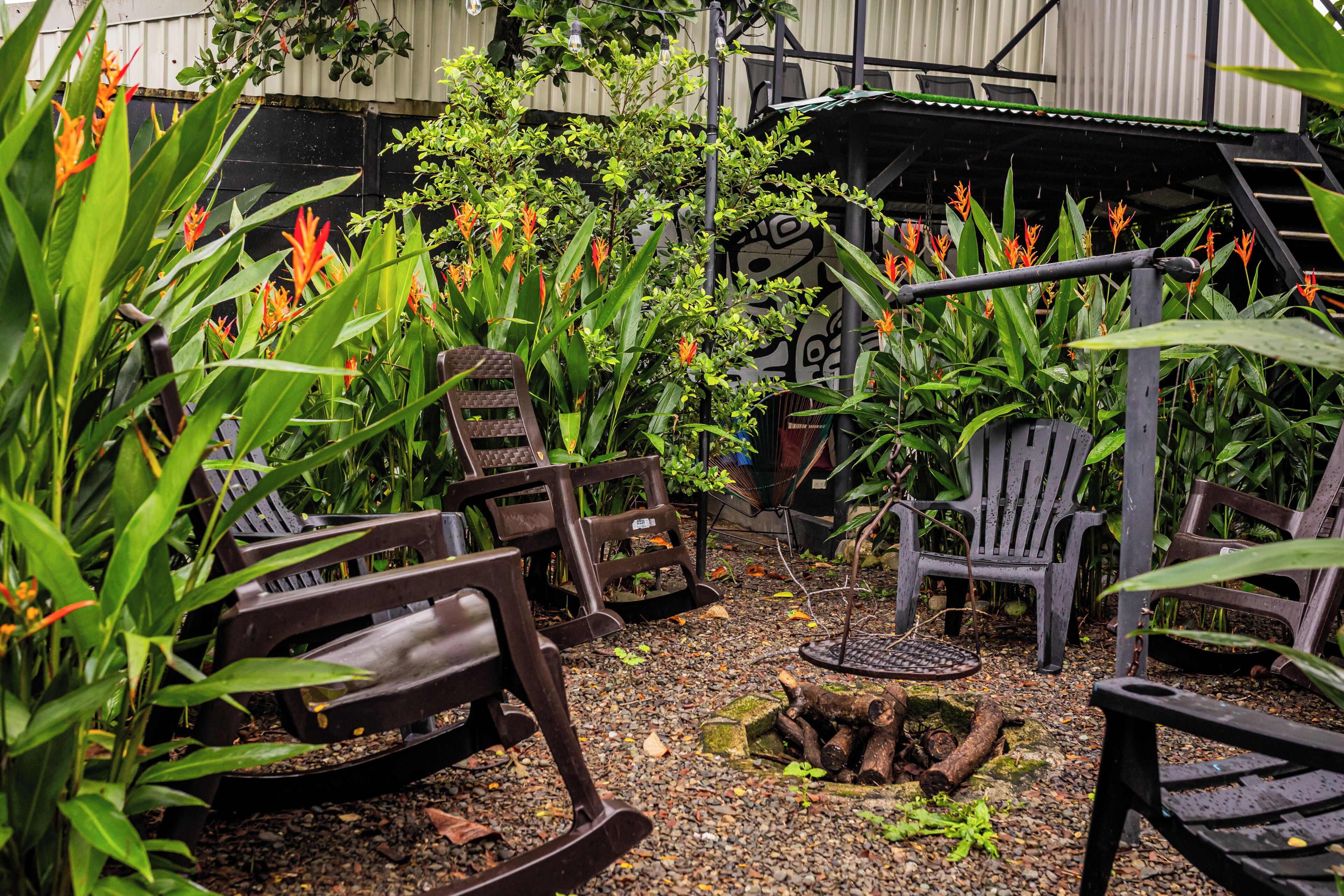 Ein Gartenbereich mit Stühlen und einer kleinen Feuerstelle.