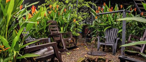 A garden area with chairs and a small fire pit.