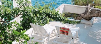 Maison d'architecte avec grandes terrasses ombragées en front de mer.