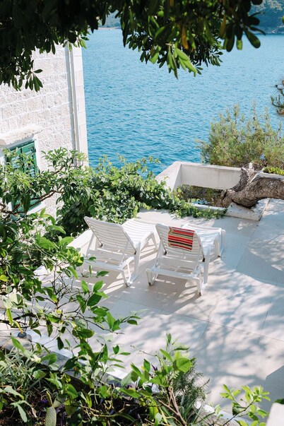 Maison d'architecte avec grandes terrasses ombragées en front de mer.