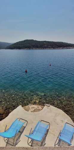 Maison d'architecte avec grandes terrasses ombragées en front de mer.
