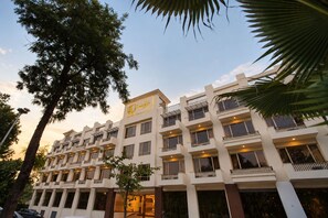 A multi-story hotel with balconies, a sign indicating it is a hotel, and a clear sky. - Roomy Signature Hotel  (Islamabad)