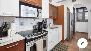 A modern kitchen with white cabinets, a black countertop, a stainless steel stove, and a refrigerator. - NEW&GORGEOUS Great View nearCondado beach 5B 2B 1 parking (San Juan)