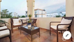 A balcony with wicker furniture, a glass table, and a potted plant. - NEW&GORGEOUS Great View nearCondado beach 5B 2B 1 parking (San Juan)