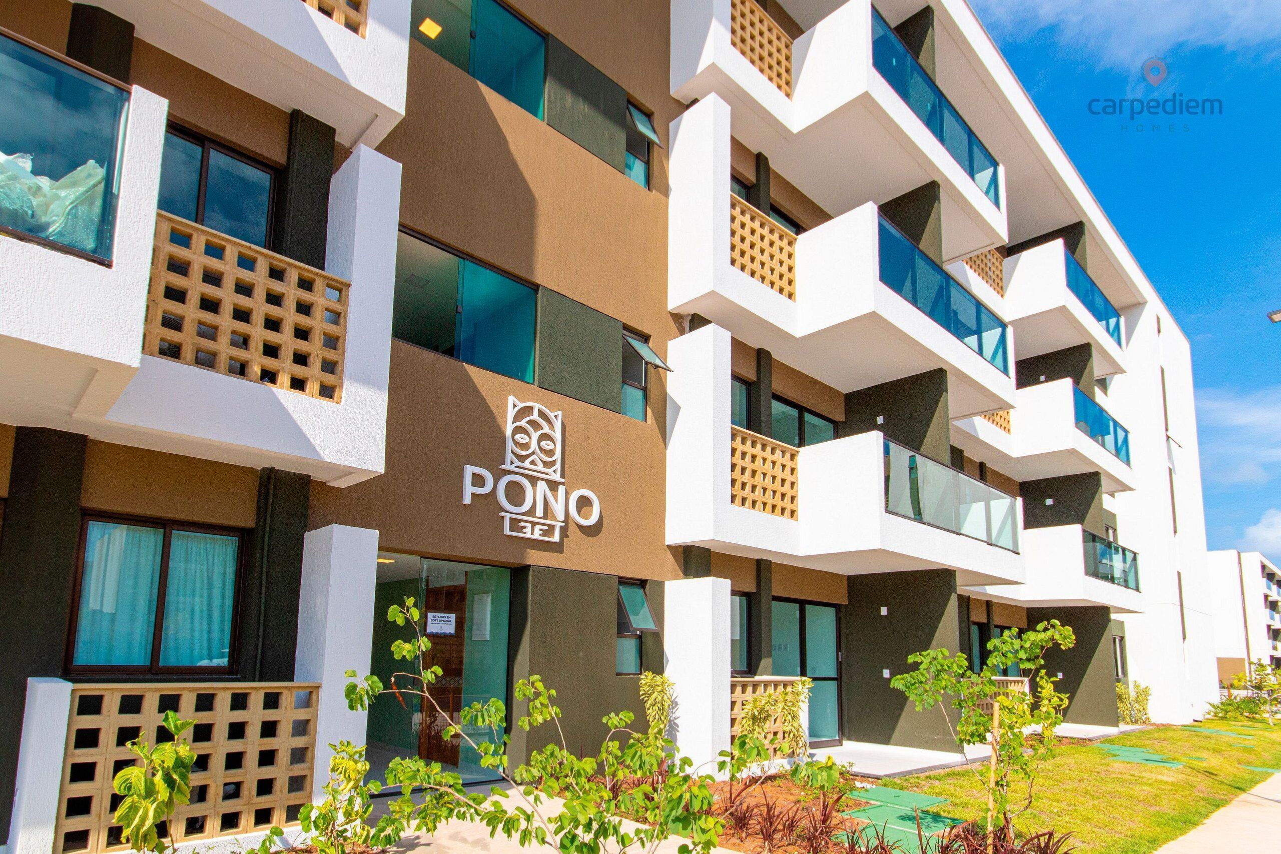 Un hotel moderno con varios balcones, un logotipo destacado y un jardín bien cuidado.