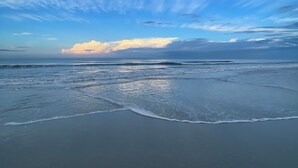 Une plage avec des vagues et un ciel dégagé.