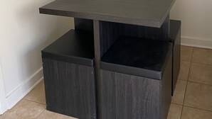 A corner table with a dark wood finish and a shelf underneath.
