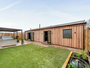 A wooden building with a patio area, a small garden, and a water feature. - The Workshop - UK42470 (Pickering)