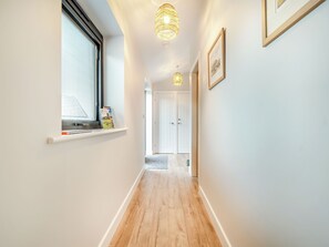 A hallway with a window, a shelf with items, a door, and a light fixture. - The Workshop - UK42470 (Pickering)