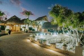 Guest rooms surround a serene courtyard with lush greenery and stone pathways.