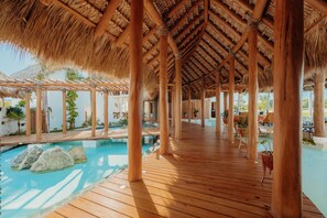 Relax by the resort's rectangular pool surrounded by lush greenery and comfortable outdoor furniture.