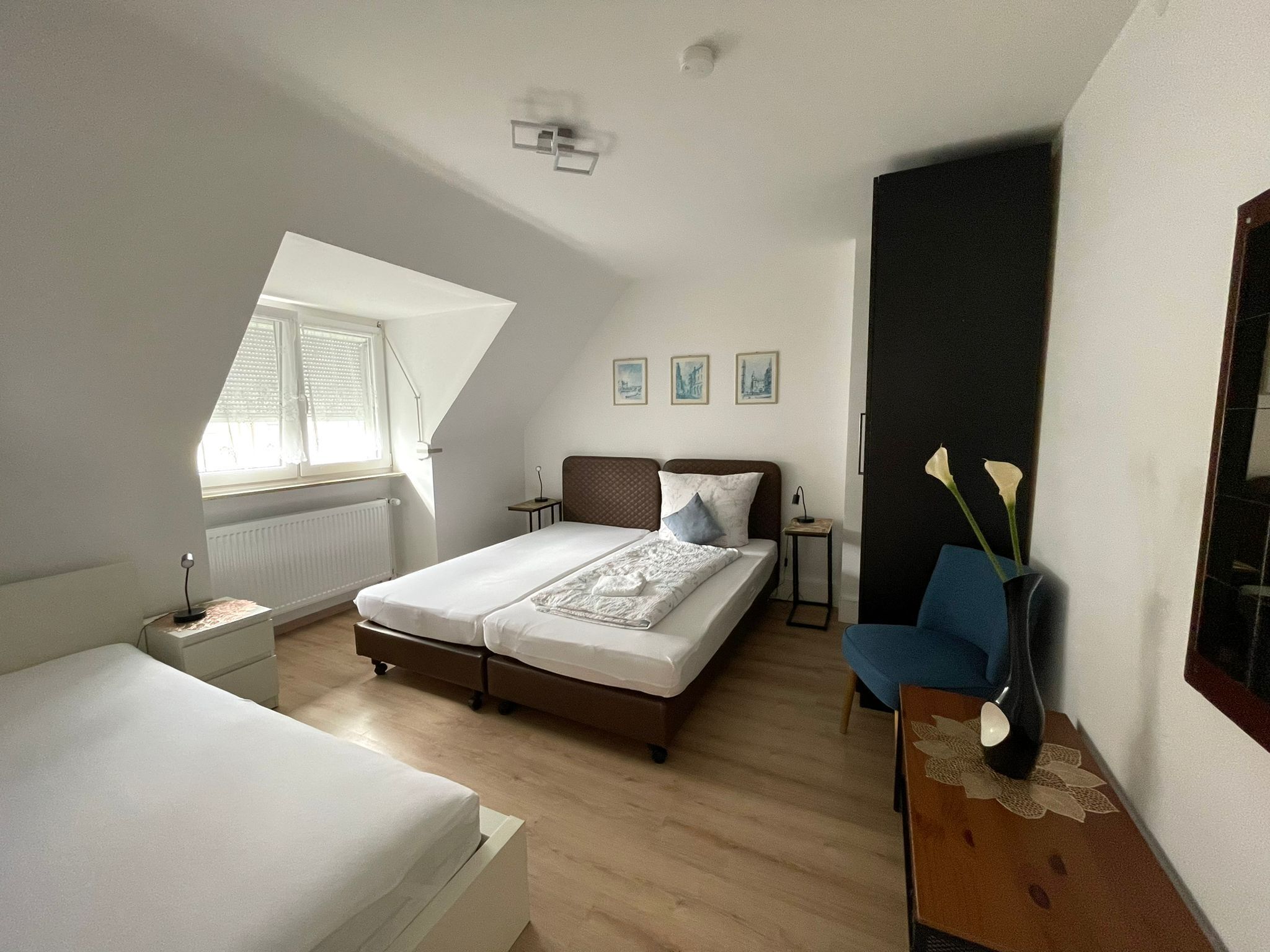 A bedroom with a bed, a desk, a chair, and a window.
