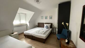 A bedroom with a bed, a desk, a chair, and a window.