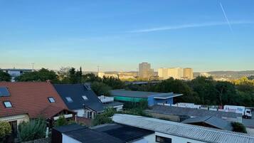 Ein Wohngebiet mit Häusern, einige mit Solaranlagen, und im Hintergrund hohe Gebäude.