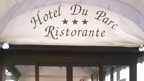 Der Eingang vom Hotel Du Parc Ristorante mit freiem Blick auf den Außenbereich und Pflanzkübeln.