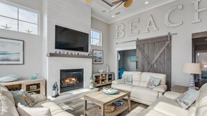 Un salón amplio con chimenea, televisor grande y una zona de estar acogedora.