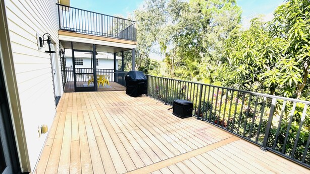 Une terrasse en bois avec un barbecue et du mobilier d’extérieur.
