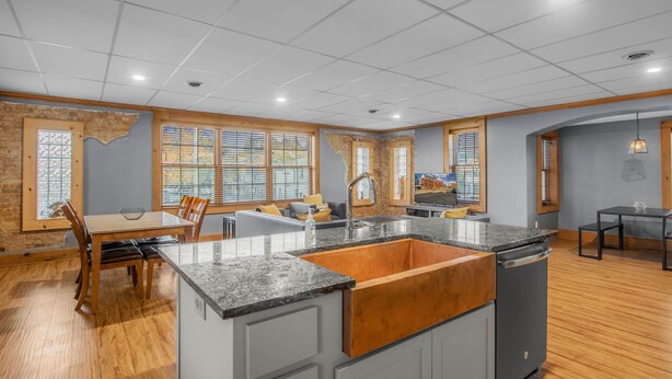 Una cocina moderna con encimera de granito, armarios de madera e instalación de lavamanos integrada.