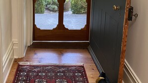 Une porte en bois avec un panneau de verre, donnant sur un paysage verdoyant.