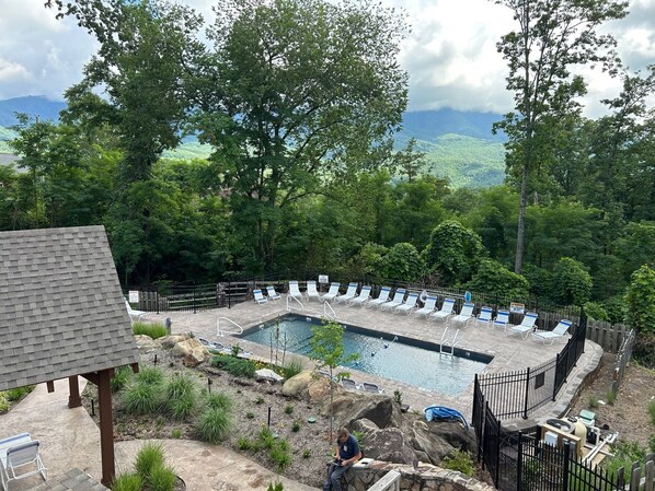 Un espace piscine avec des chaises longues et une vue sur les montagnes.