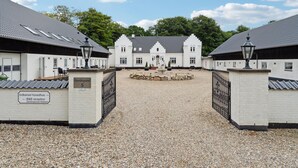 Een gebouw met een grindpad dat leidt naar een poort.