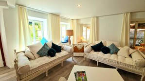 A spacious living room with two white sofas, a coffee table, and a lamp. - Allegra Appenzell (Trogen)