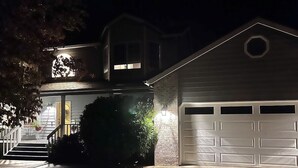 A residential house with a garage, a staircase leading to the entrance, and a well-lit front porch. - Sopra Bella- Elegant 4BR, Family Friendly, OSU (Corvallis)