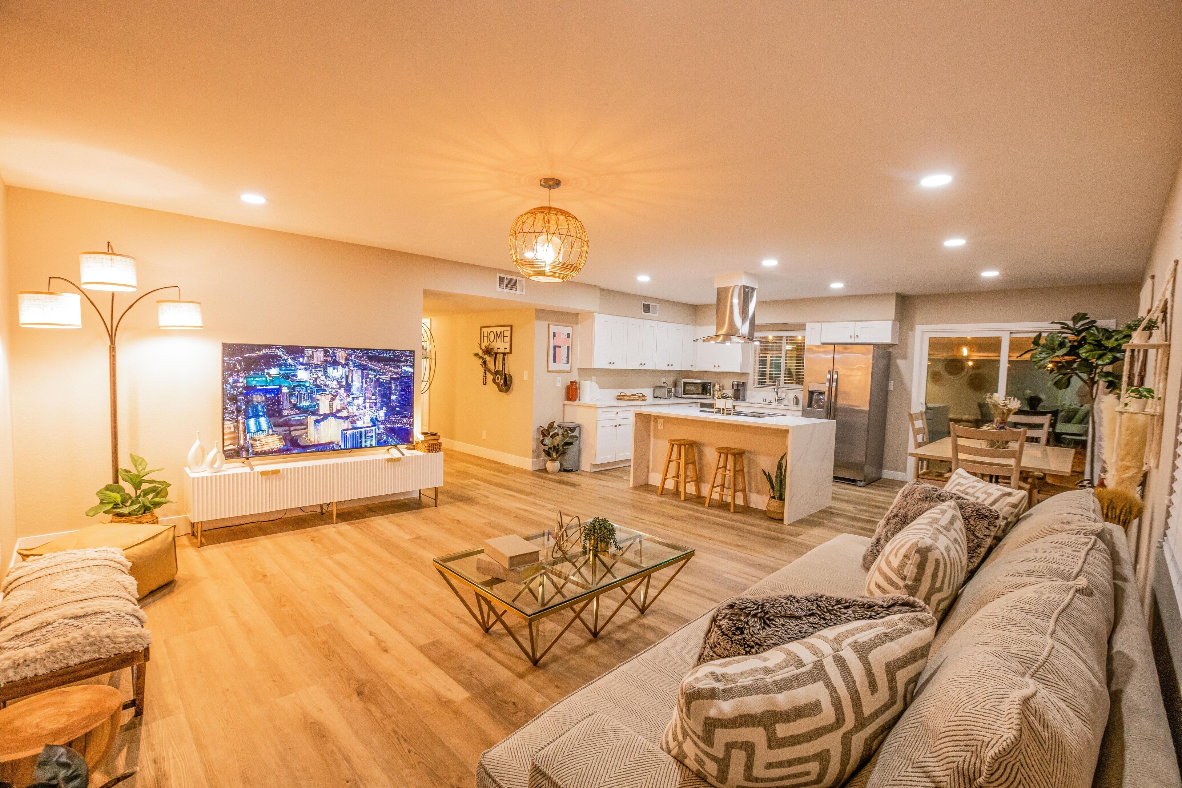 Una sala de estar moderna con una mesa de centro de vidrio, un sofá y un televisor.
