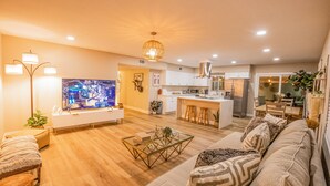 Una sala de estar moderna con una mesa de centro de vidrio, un sofá y un televisor.