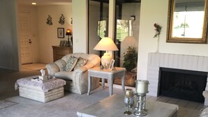 A living room with a fireplace, a sofa, a coffee table, and a rug.