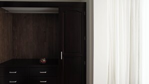 Un armario de madera oscura con un espejo y un pequeño adorno en la repisa superior.