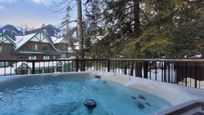 Un bain à remous avec vue sur un chalet et les montagnes.
