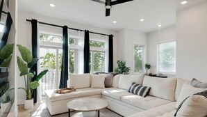 A modern living room with a sectional sofa, a round coffee table, and large windows with curtains. - 2mi to DT, 4 Private Rooms, Roof Deck Amazing View (Nashville)