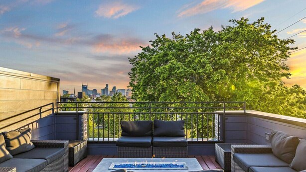A rooftop terrace with wicker furniture, a fire feature, and a city skyline view. - 2mi to DT, 4 Private Rooms, Roof Deck Amazing View (Nashville)