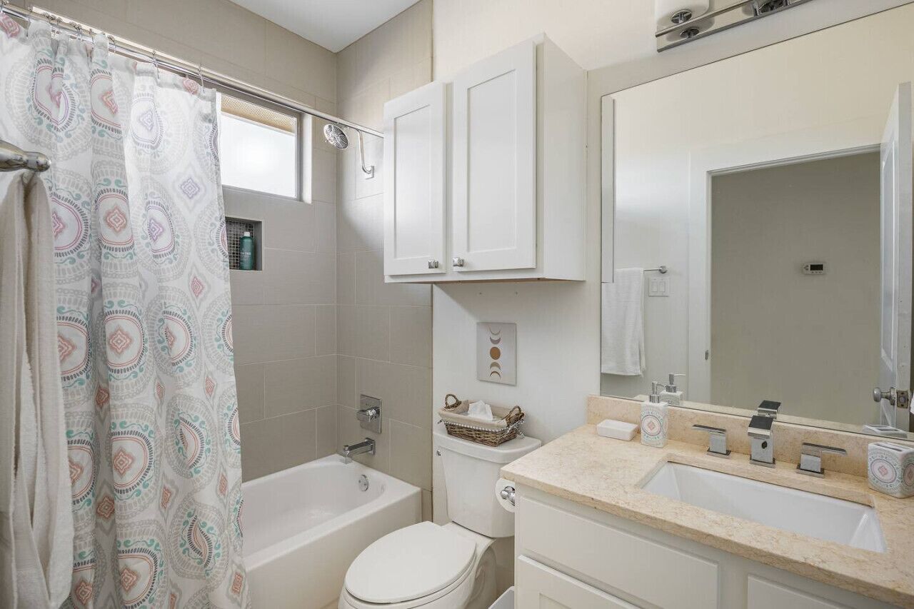A bathroom with a bathtub, toilet, and sink.