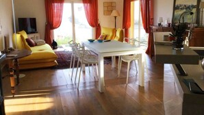 A living room with a yellow sofa, white dining table, and red curtains. - Villa Roccu (Borgo)