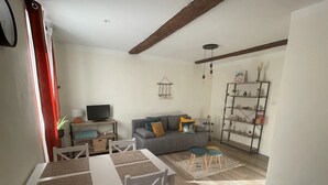 A living room with a sofa, TV, and a bookshelf.