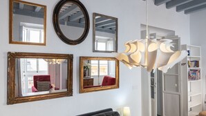 A room with a white wall, multiple mirrors, a chandelier, and a bookshelf. - Apartament Sweet Home in Cádiz (Cádiz)