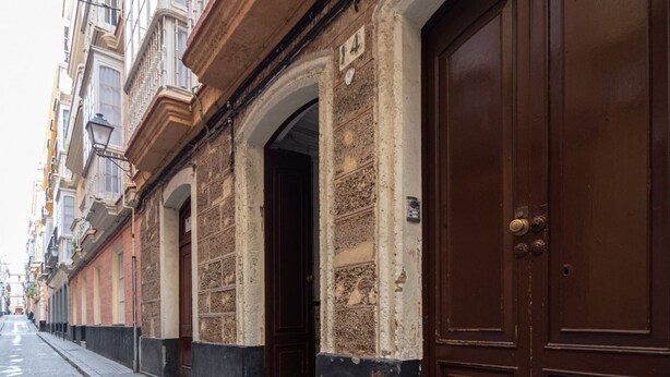 A row of traditional buildings with large wooden doors and arched windows. - Apartament Sweet Home in Cádiz (Cádiz)