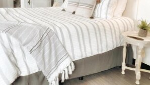 Ein Schlafzimmer mit Bett, Nachttisch und Spiegel.