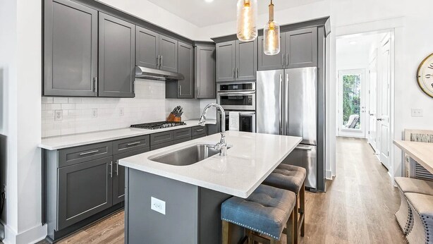 A modern kitchen with grey cabinets, stainless steel appliances, and a central island with stools. - Beautiful 30A Beach House - short walk to beach! (Santa Rosa Beach)