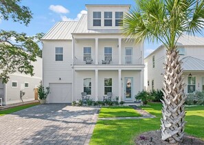 A two-story house with a front porch, a garage, and a well-maintained lawn.